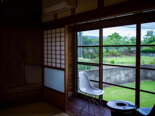 a white chair sitting in front of a window at OMISIHMA SPACE Hanare in Kamiura