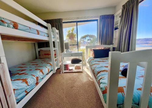 two bunk beds in a room with a window at Lake Vista Lodge in Jindabyne