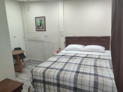 a bedroom with a bed with a plaid blanket at Estancia WLC in Ayutuxtepeque