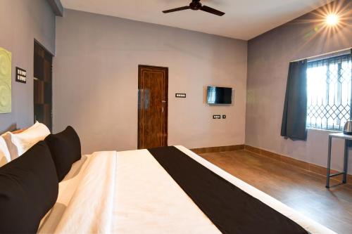 a bedroom with a bed and a ceiling fan at Hotel O Neatflix &Chill in Khandagiri