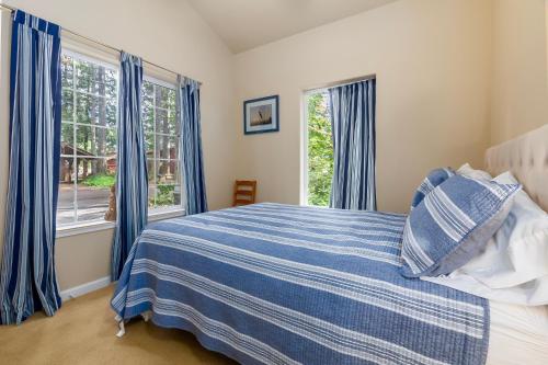a bedroom with a bed with blue curtains and a window at Fairway Paradise in Packwood