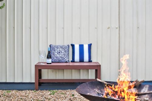 Una fogata con un banco y una copa de vino. en Beachwood - Fabulous Front-Row Goolwa Beach, Pet Friendly, en Goolwa South