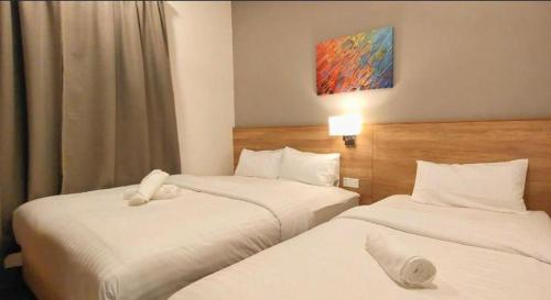 a hotel room with two beds and a painting on the wall at Theme Park Ipoh - Onsen Premier Suites By MICASA GROUP in Ipoh