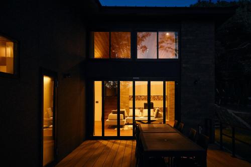 a house with a wooden deck with a table at COCO VILLA 那須高原-Sauna- in Nasu