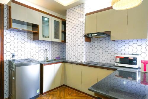 a kitchen with a refrigerator and a microwave at Mama Hotel And Apartment - Free Sauna And Gym in Da Nang