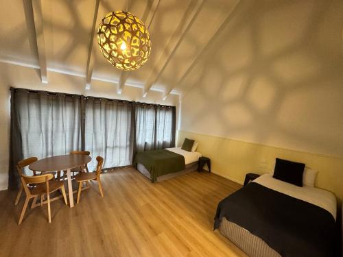 a room with a table and a bed and a dining room at Mt Wellington Motel in Auckland