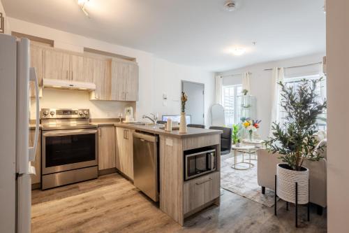 a kitchen with stainless steel appliances and a living room at Fashionable 3BR in Griffintown in Montréal