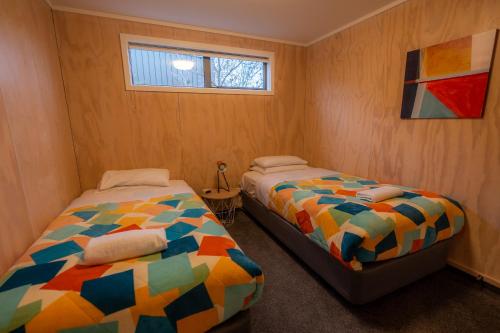 a bedroom with two beds and a window at Starlight Townhouse in Twizel