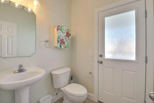 a bathroom with a toilet and a sink and a mirror at 7076 - JMJ Seascape in Nags Head