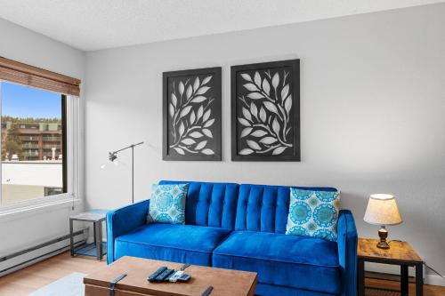 a blue couch in a living room with a window at Blazing Saddles 102 by Summit County Mountain Retreats in Breckenridge
