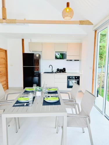 a kitchen and dining room with a table and chairs at Baan Saint-Tropez Seaview Villas Kata Beach in Kata Beach