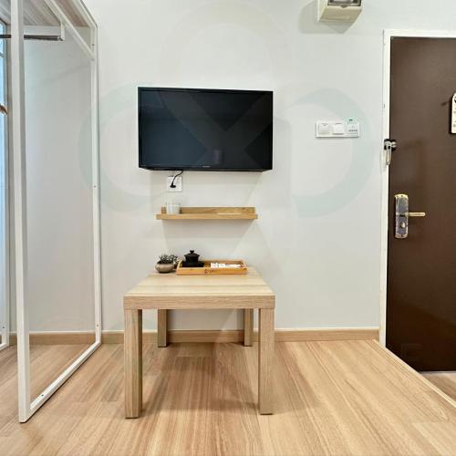 a room with a table and a tv on a wall at S8 Boutique Hotel near KLIA 1 & KLIA 2 in Sepang