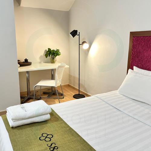 a bedroom with a bed and a table and a desk at S8 Boutique Hotel near KLIA 1 & KLIA 2 in Sepang