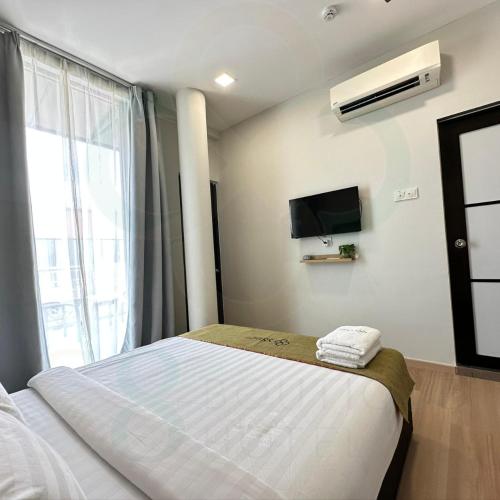 a bedroom with a bed and a tv and a window at S8 Boutique Hotel near KLIA 1 & KLIA 2 in Sepang