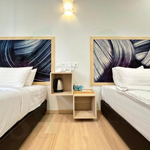 two beds sitting next to each other in a room at S8 Boutique Hotel near KLIA 1 & KLIA 2 in Sepang
