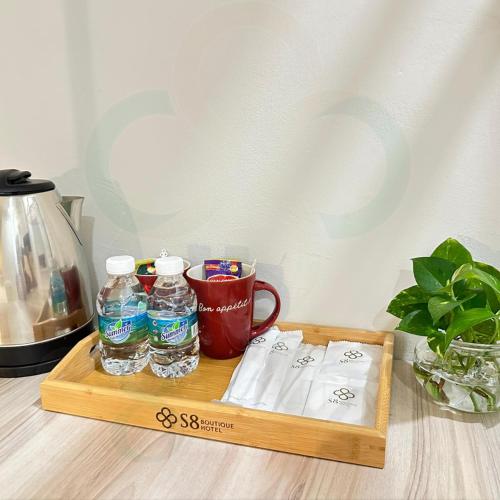 a wooden tray with bottles of water and a mug at S8 Boutique Hotel near KLIA 1 & KLIA 2 in Sepang