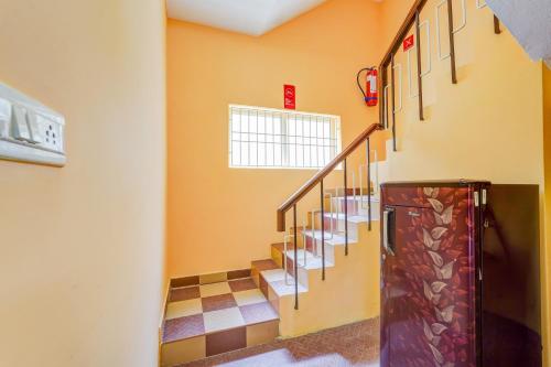 a hallway with stairs in a building at Super Hotel O Velachery Near Devi Karumariamman Nagar Extension in Chennai