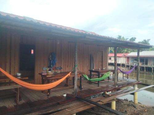 a house with a hammock on a deck at Friend of Nature Homestay in Kaôh Rŭng (5)