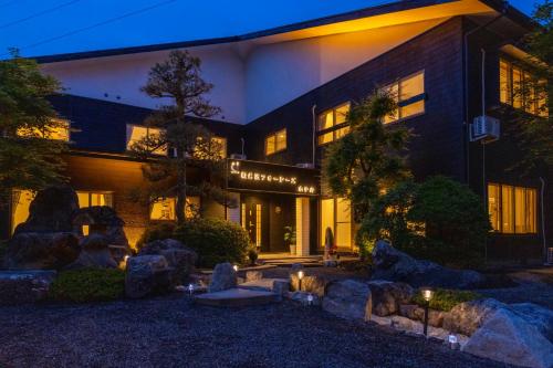 a building with rocks in front of it at night at 軽井沢フォーシーズホテル in Karuizawa