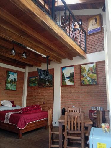 a bedroom with a bed and a table and chairs at "Arte en el desván" Rustic loft - Desván rústico in Tenancingo de Degollado