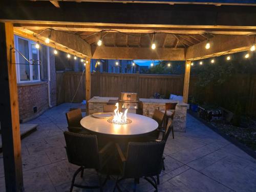a patio with a table and chairs and lights at Your Luxurious Caledon Escape in Brampton