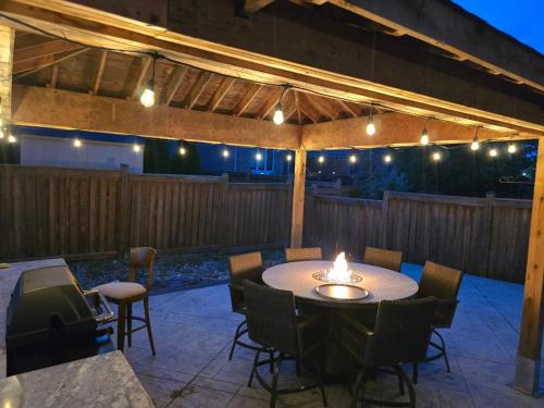 a patio with a table and chairs and lights at Your Luxurious Caledon Escape in Brampton