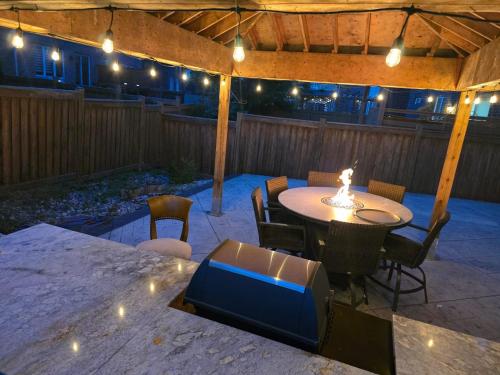 a patio with a table and chairs and lights at Your Luxurious Caledon Escape in Brampton