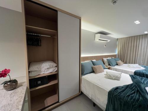a bedroom with two beds and a mirror at Quality Suítes - Ao lado da Orla - Flat com Vista Mar in João Pessoa