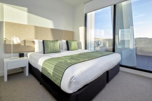 a bedroom with a large bed and a large window at 381 Cremorne in Melbourne