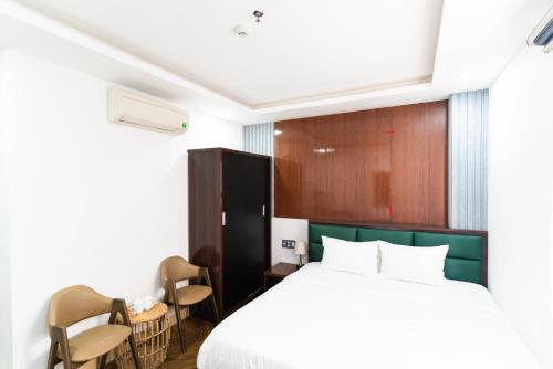 a hotel room with a bed and chairs at Mama Hotel And Apartment - Free Sauna And Gym in Da Nang