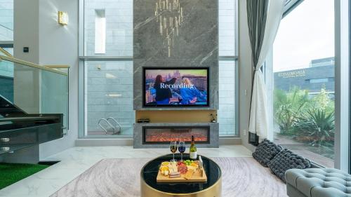 a living room with a fireplace and a tv at Eudaimonia Poolvilla Jeju 에다모니아 함덕풀빌라 in Jeju