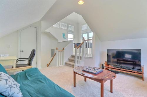 a living room with a blue couch and a tv at BB47 - A Wave From It All in Kill Devil Hills