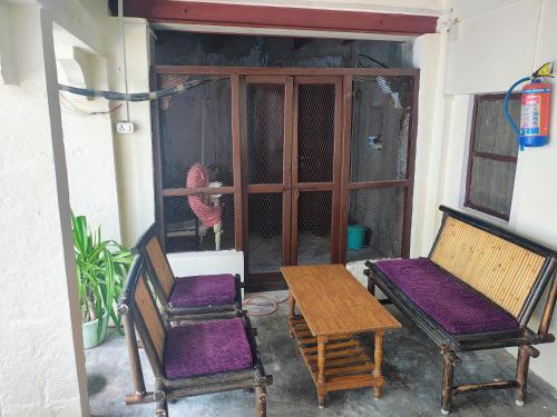 a porch with two chairs and a table and a bird at Radha Krishna Home in Varanasi
