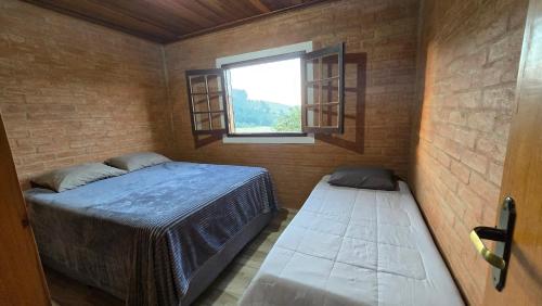 a small room with a bed and a window at Casa Da Floresta Cercada com Piscina in Santo Antônio do Pinhal