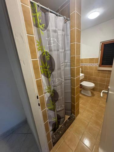 a bathroom with a shower with a toilet and a shower curtain at Studio Apartment Bella in Selca