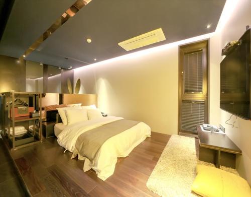 a bedroom with a bed and a desk and a window at JS Boutique Hotel in Hwaseong