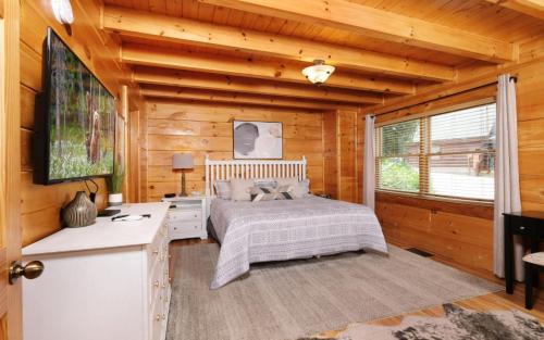 a bedroom with a bed in a wooden cabin at Rockin in the Smokies in Pigeon Forge