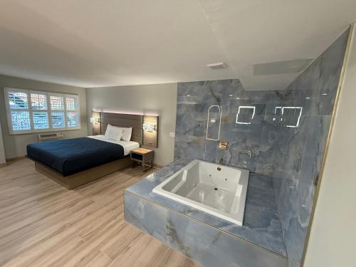 a bedroom with a bed and a tub in a room at Rosemead Motel in Rosemead