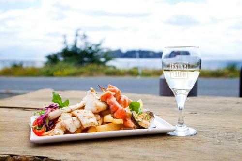 a plate of food next to a glass of wine at Bruny Island Escapes and Hotel Bruny in Alonnah