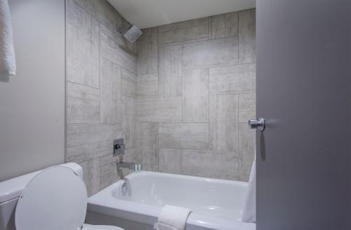 łazienka z białą wanną i toaletą w obiekcie Grand Marshal Inn w mieście Hythe