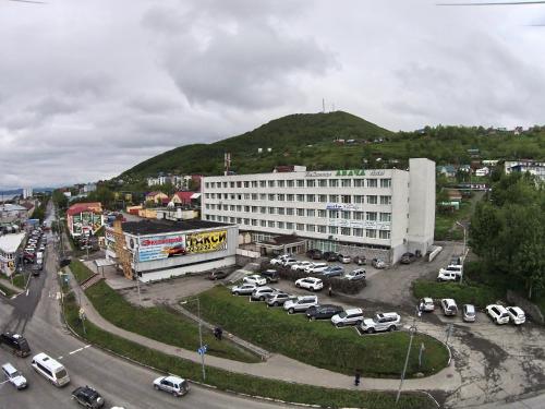 un gran edificio con coches estacionados en un estacionamiento en Avacha Hotel, en Petropávlovsk-Kamchatski