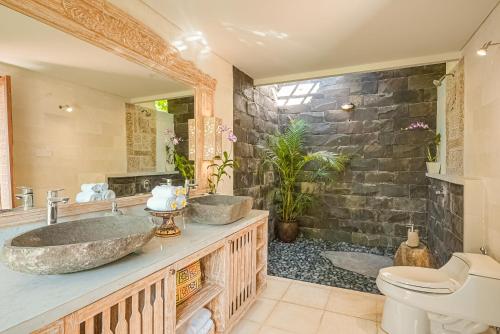 a bathroom with two sinks and a toilet at Maha Hills Resort by Mahaprana Experience in Lovina
