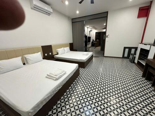 a room with two beds and a room with a bathroom at Phố Biển Homestay & Apartment in Ðình Loan