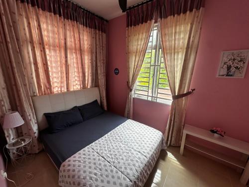 a bedroom with a bed and a window at The Deck Homestay & Event House in Jitra