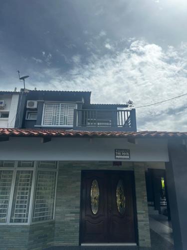 a building with a door with a sign on it at The Deck Homestay & Event House in Jitra