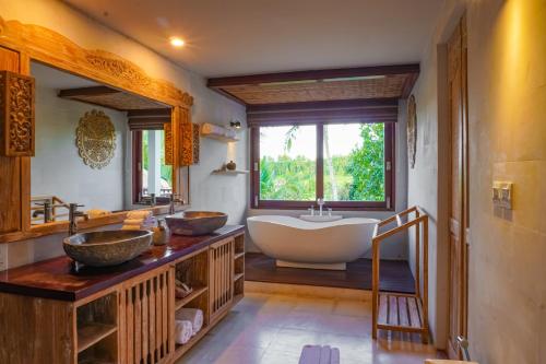 a bathroom with two sinks and a large tub at Maha Hills Resort by Mahaprana Experience in Lovina