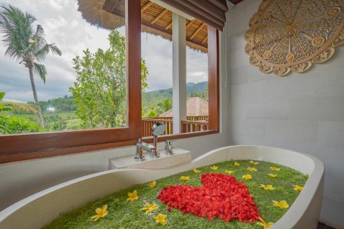 a bathroom with a bath tub filled with red flowers at Maha Hills Resort by Mahaprana Experience in Lovina