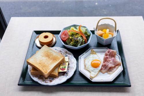 a tray of food with breakfast foods on a table at 軽井沢フォーシーズホテル in Karuizawa