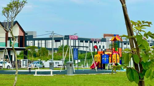a playground in a park in front of a building at Warm & Cozy Home in Kampong Duson Gilap
