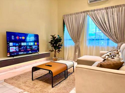 a living room with a couch and a tv at Warm & Cozy Home in Kampong Duson Gilap